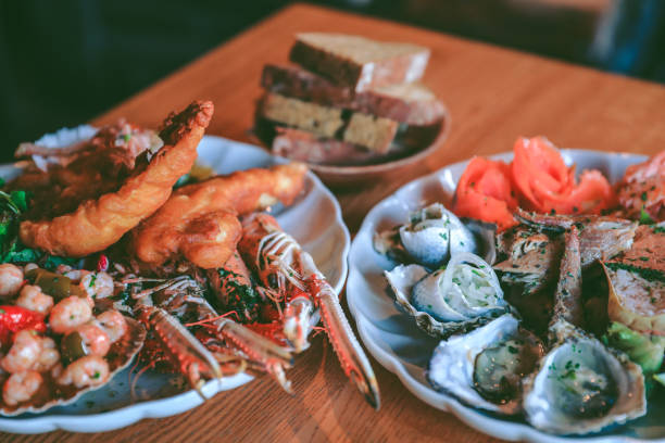Table top view of breakfast food displayed on table, people eating food.