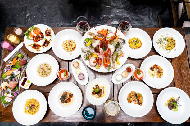 Table top view of breakfast food displayed on table, people eating food.